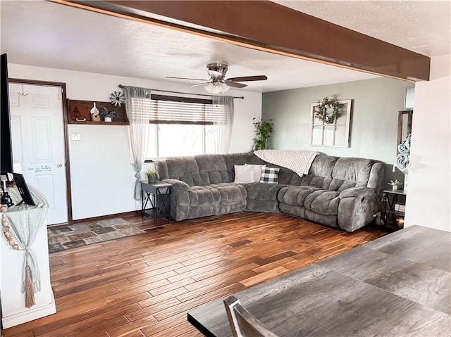 living room with hardwood / wood-style flooring, ceiling fan, and a textured ceiling