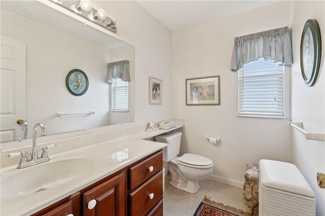 bathroom with vanity, tile patterned floors, toilet, and a healthy amount of sunlight