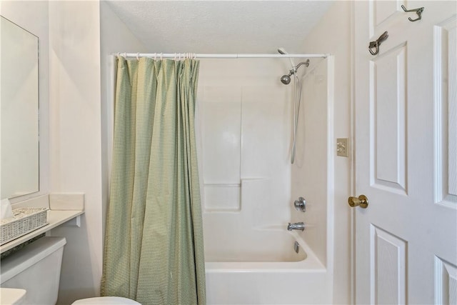 bathroom featuring shower / bath combo, a textured ceiling, and toilet