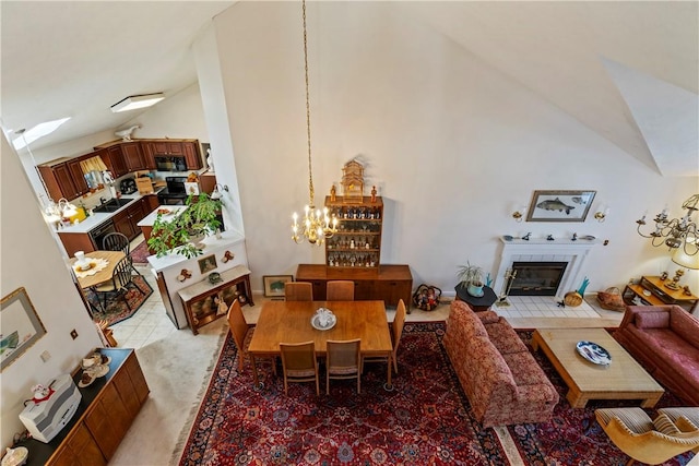 dining room with high vaulted ceiling, a tile fireplace, and a notable chandelier