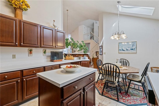 kitchen featuring a skylight, a chandelier, hanging light fixtures, light tile patterned floors, and a kitchen island