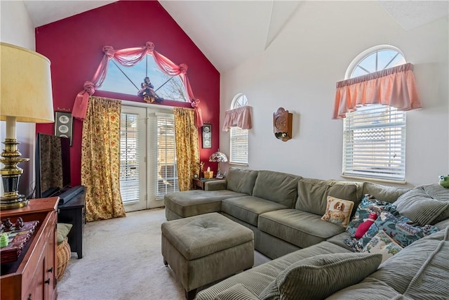 carpeted living room featuring high vaulted ceiling and french doors