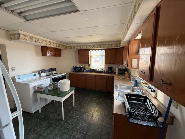 kitchen featuring a drop ceiling, sink, separate washer and dryer, and white range with electric cooktop