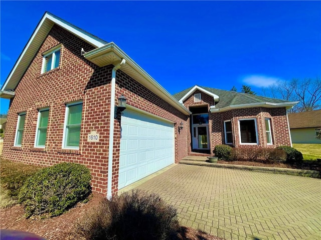 single story home featuring a garage, brick siding, and driveway