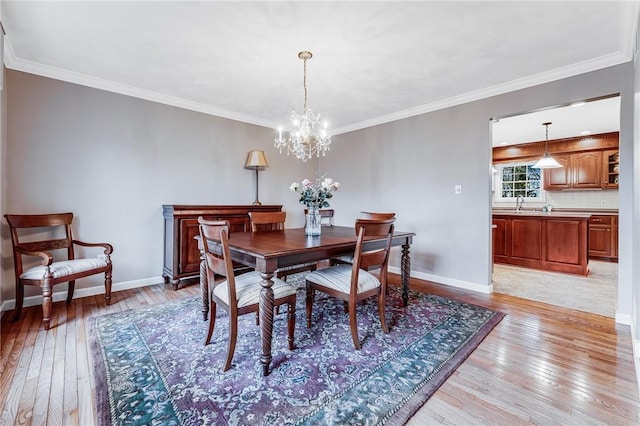 dining space with crown molding and light hardwood / wood-style floors