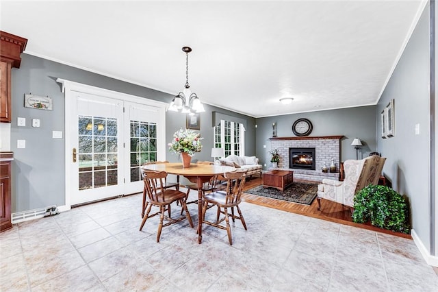 dining room with crown molding, a fireplace, and a notable chandelier