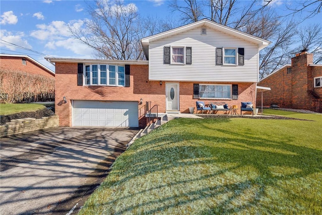 split level home featuring a garage and a front lawn