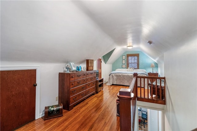 bedroom with vaulted ceiling and hardwood / wood-style floors