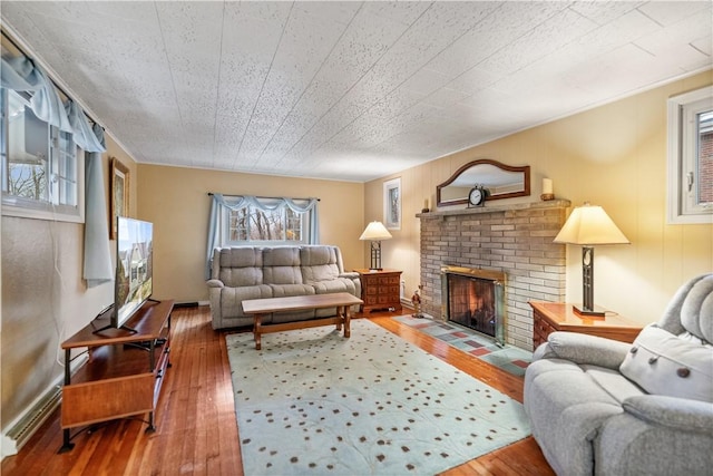 living room with hardwood / wood-style flooring and a brick fireplace