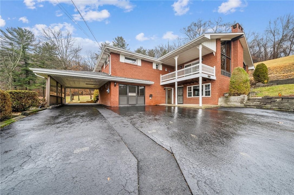 view of property with a balcony and a carport