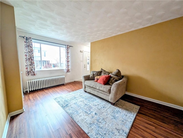 living room with hardwood / wood-style flooring, radiator, and a textured ceiling