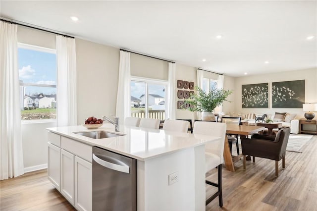 kitchen with sink, dishwasher, an island with sink, and white cabinets