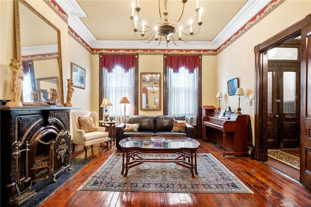 sitting room with dark hardwood / wood-style flooring, ornamental molding, and an inviting chandelier