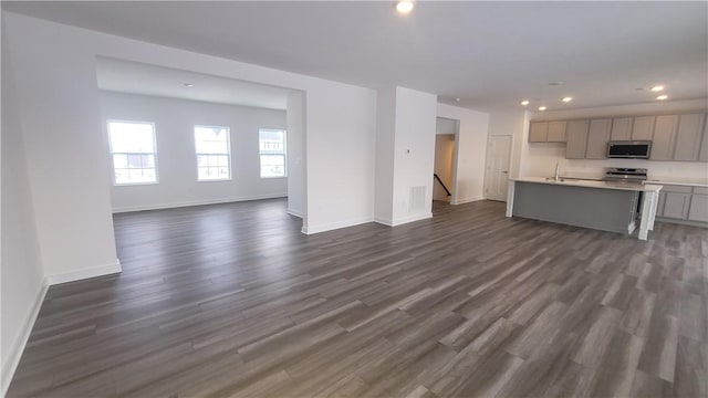 unfurnished living room with dark wood-type flooring and sink