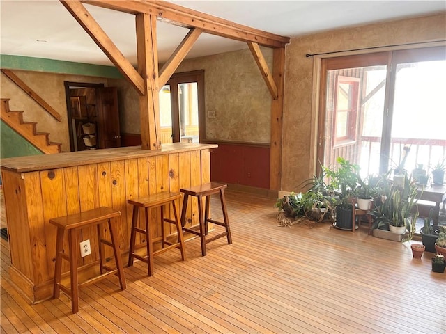 bar featuring beam ceiling and light wood-type flooring