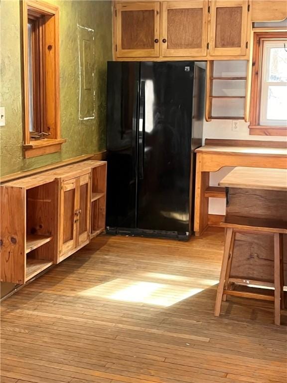 kitchen with black refrigerator and light hardwood / wood-style floors