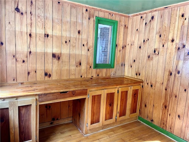 interior space with hardwood / wood-style floors and wood walls