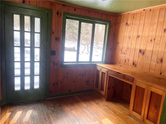 doorway to outside featuring wood walls and light hardwood / wood-style flooring