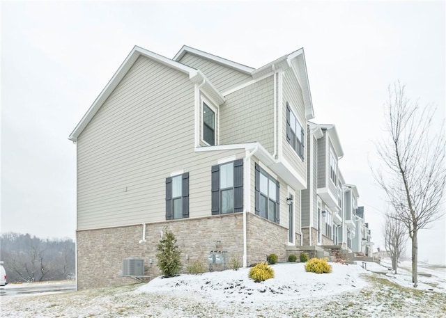 snow covered property featuring central AC unit