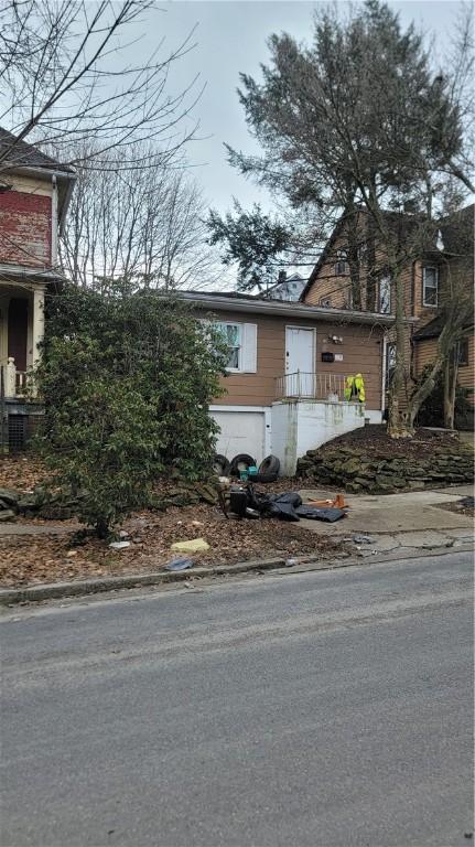 view of front of home with a garage and central AC