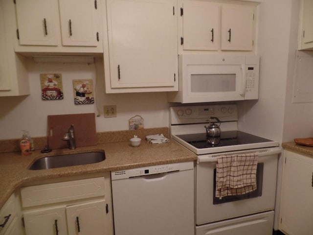 kitchen with white appliances, a sink, white cabinetry, and light countertops