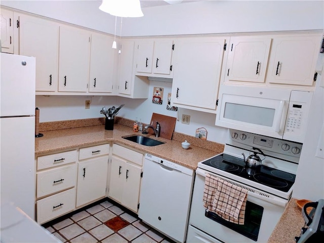 kitchen featuring white appliances, a sink, light countertops, and white cabinetry