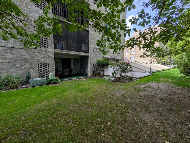 back of house featuring a yard and brick siding