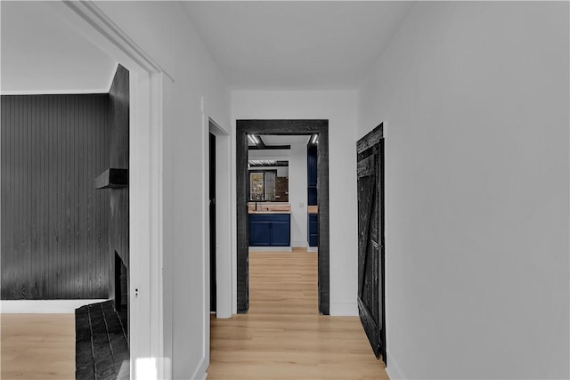 hallway with sink and light hardwood / wood-style flooring