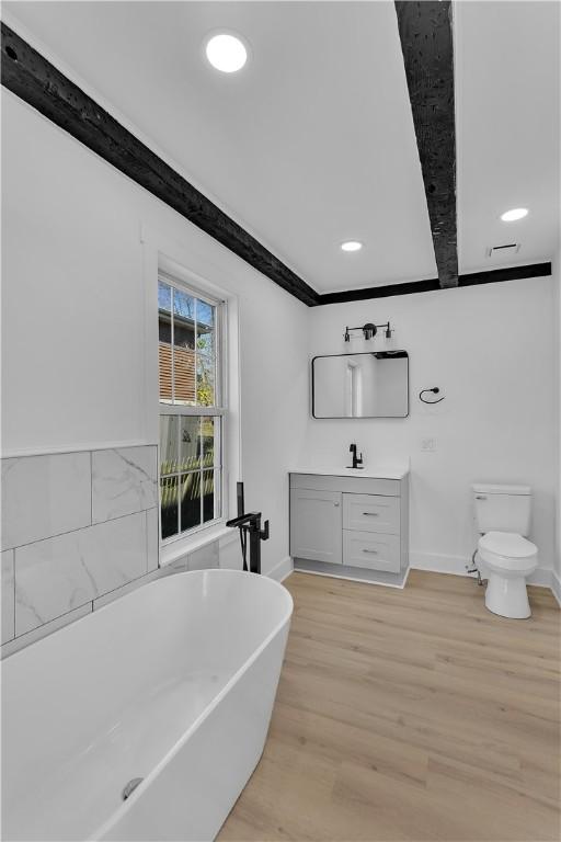 bathroom featuring vanity, toilet, a bathtub, and hardwood / wood-style floors