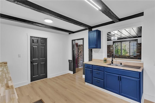 kitchen featuring sink, beam ceiling, light hardwood / wood-style floors, and blue cabinets