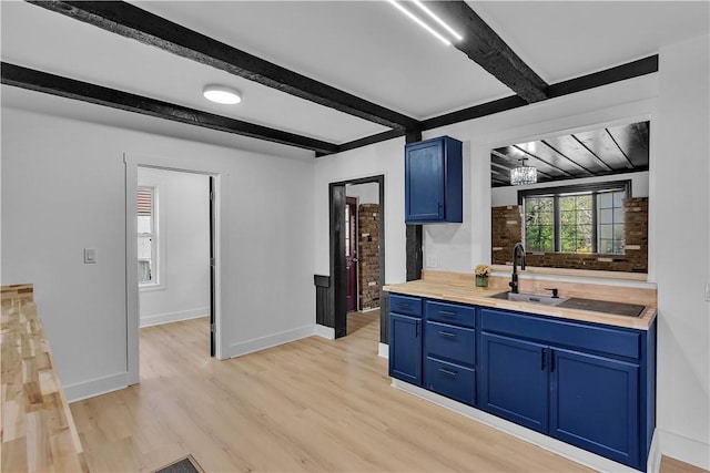 kitchen with sink, beam ceiling, blue cabinetry, and light wood-type flooring