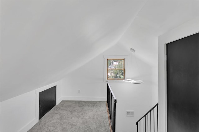 additional living space featuring light colored carpet and lofted ceiling