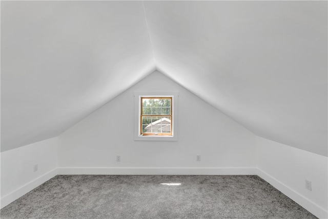 bonus room with light carpet and vaulted ceiling