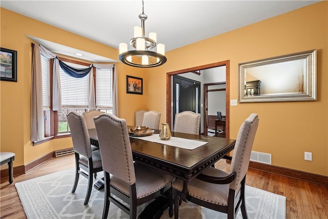 dining space featuring an inviting chandelier and light wood-type flooring