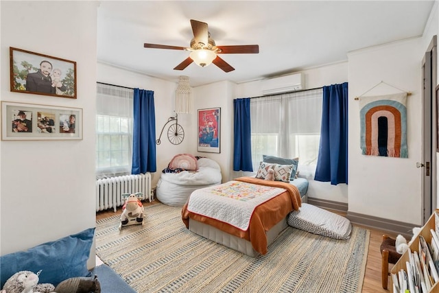 bedroom featuring hardwood / wood-style flooring, ceiling fan, radiator heating unit, and a wall mounted AC