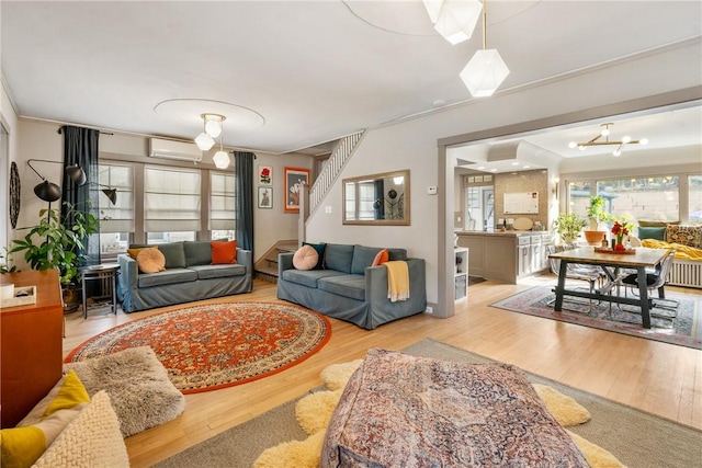 living room with a wall mounted AC and light wood-type flooring