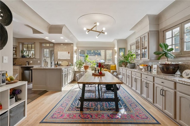 dining space featuring sink, light hardwood / wood-style floors, and a notable chandelier