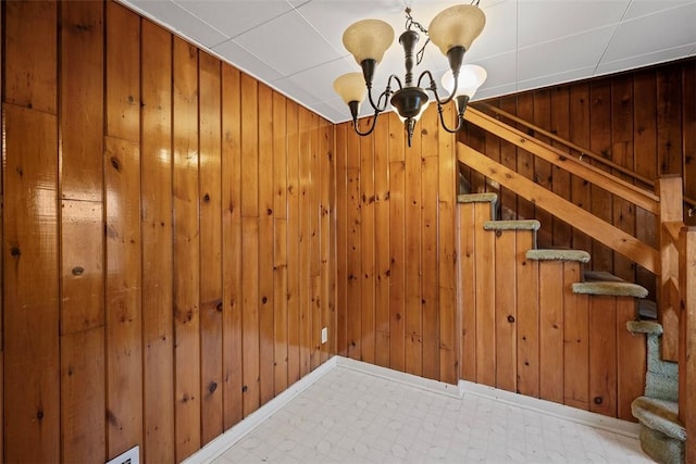 interior space featuring a chandelier and wood walls