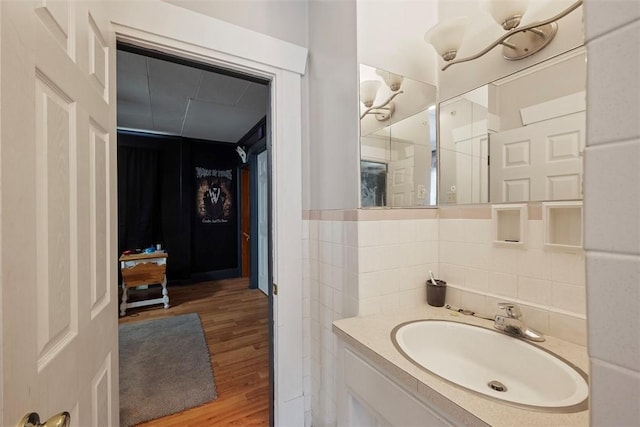 bathroom with vanity, hardwood / wood-style floors, and tile walls