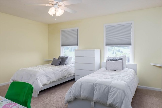 carpeted bedroom with multiple windows and ceiling fan