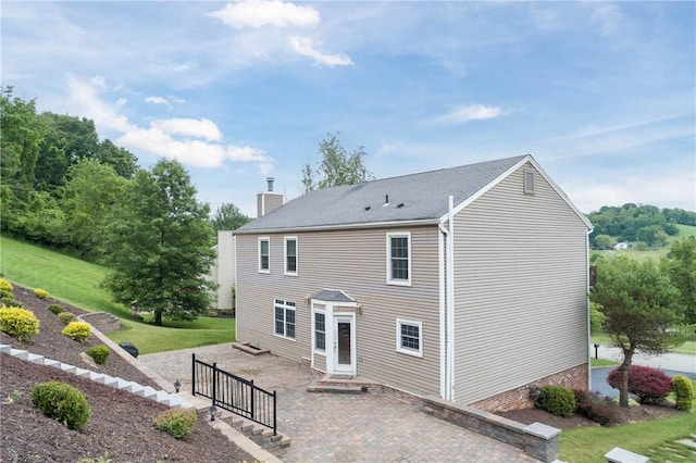 rear view of property featuring a patio area and a lawn