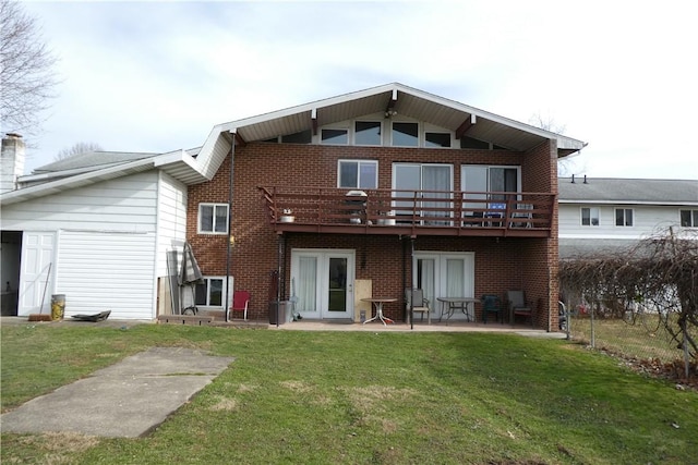 rear view of property with a yard, french doors, a patio, and brick siding