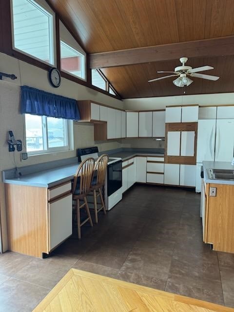 kitchen featuring white appliances, wood ceiling, ceiling fan, vaulted ceiling with beams, and white cabinetry