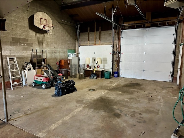 garage featuring a garage door opener and concrete block wall