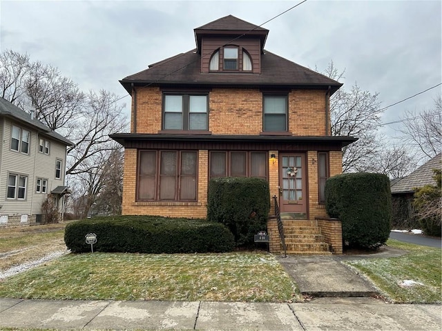 american foursquare style home with a front lawn and brick siding