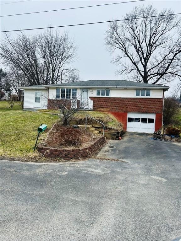 view of front of property with a garage and a front lawn