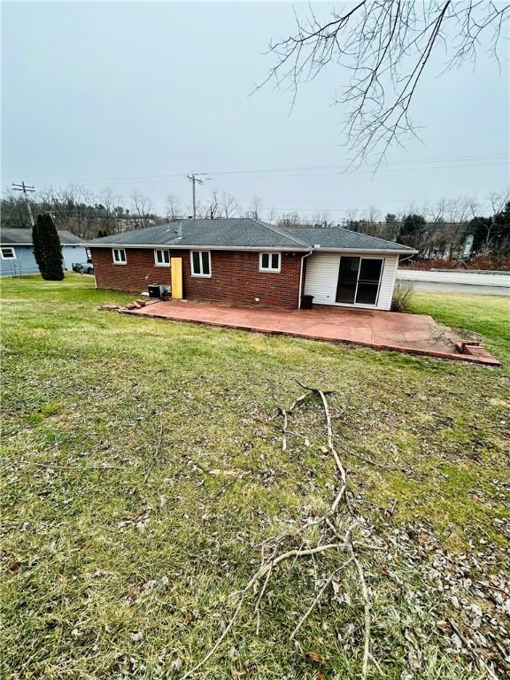 back of property featuring a patio area and a lawn