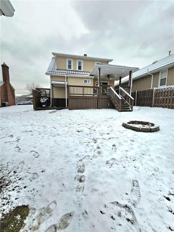 snow covered rear of property featuring a wooden deck