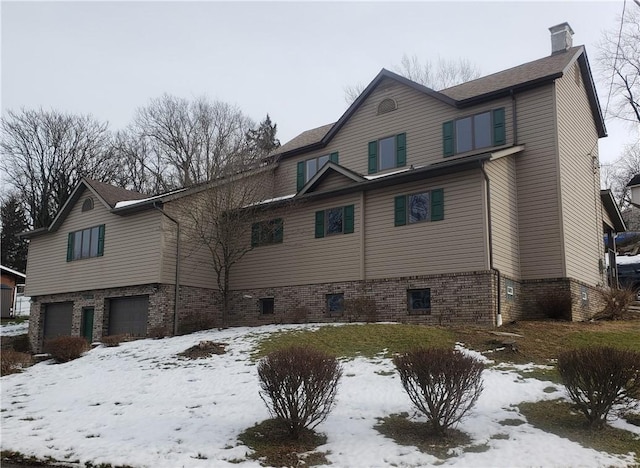 view of snowy exterior featuring a garage