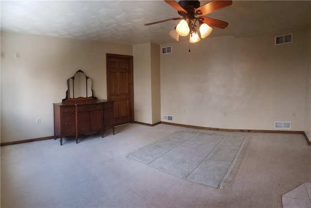 spare room featuring light carpet and ceiling fan